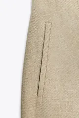 Pantalón culotte gris de tiro alto con bolsillos delanteros de vivo. Pierna ancha y cierre frontal con cremallera y gancho metálico.