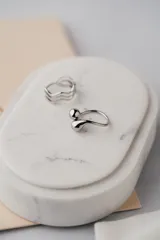 Anillo plateado de acero quirúrgico con diseño de gota ajustable.