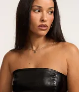 Blusa corta de cuero sintético negro, sin mangas, con cuello alto de encaje y cierre lateral con cremallera.