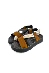 Sandalias de cuero con tiras cruzadas color marrón, negro y dorado, con hebilla de ajuste y suela de goma negra.