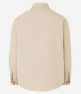 Camisa marrón de manga larga, confeccionada en sarga, con cuello inglés, abotonado delantero, bolsillos en el pecho con solapa y puños abotonados.