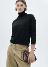 Sweater negro de punto fino con cuello alto y mangas largas.