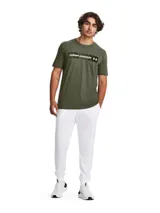 Remera blanca de Under Armour con estampado camuflado en el pecho y logo de la marca en negro.