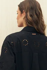 Camisa celeste de manga larga con cuello camisero y botones de nácar. Presenta detalles de broderie calado en el canesú y las mangas.