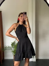 Vestido corto rojo con escote halter, corte a la cintura y falda con volados.