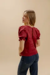 Blusa negra de lino con mangas abullonadas y puños elásticos.