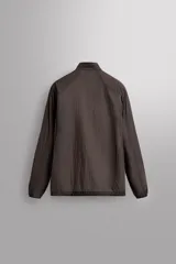 Cazadora relaxed fit confeccionada en tejido técnico ligero color marrón. Cuello subido, manga larga acabada en puño con elástico, bolsillos frontales en cadera con cierre de cremallera oculta en costura y cierre frontal con cremallera.