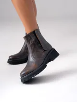 Bota de cuero vacuno color marrón, con suela de goma artesanal y elástico lateral.