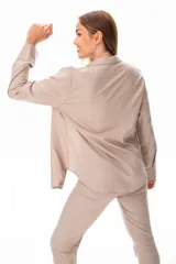 Conjunto color beige compuesto por camisa de manga larga con botones, musculosa blanca de breteles finos y pantalón largo de vestir.