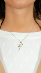 Cadena con colgante en forma de serpiente decorada con piedras verdes y doradas.
