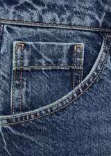 Falda midi de jean azul con corte evasé y terminación asimétrica.