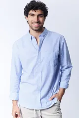 Camisa celeste a rayas verticales blancas, de corte clásico, con cuello abotonado y bolsillo en el pecho.