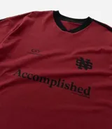 Remera deportiva masculina oversized color gris oscuro con cuello en V blanco, mangas cortas con rayas blancas, estampa localizada y lettering blanco.