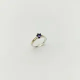 Anillo solitario en plata y oro con circonia violeta redonda engarzada.