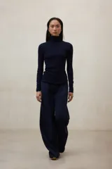 Pantalón de vestir azul marino, de corte ancho y tiro alto, con pliegues frontales.