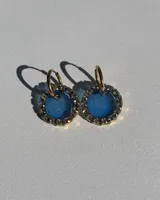 Aros colgantes con aro de acero quirúrgico dorado y dije circular de resina azul con borde de strass.