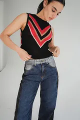 Chaleco calado negro con diseño de rayas diagonales rojas, beige y blancas.