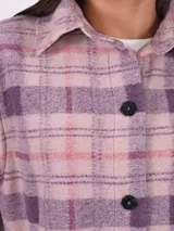 Sobrecamisa larga a cuadros color lila, rosa y borgoña, con cuello camisero y cierre frontal con botones negros.