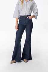 Jean acampanado de tiro alto, color azul oscuro, con detalles de costura visibles y acabado deshilachado. Confeccionado en denim de algodón y lycra.