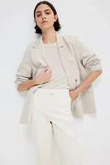 Pantalón cigarette tobillero color blanco, con cintura estándar, cierre y pretina prolongada con corchete oculto. Piernas ajustadas con abertura corta en los bajos, bolsillos al bies y bolsillo de atrás decorativo. Pliegues adelante y atrás.