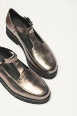Zapato guillermina color bronce con acabado charol, suela de goma negra y plataforma.