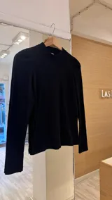 Remera manga larga color verde oliva, confeccionada en tejido morley de algodón con detalle fruncido en los hombros.