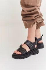 Sandalias negras con plataforma y doble tira con ajuste de velcro.