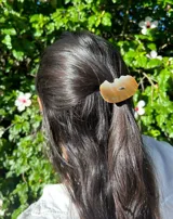 Goma de pelo con pieza de nácar color crema y marrón.