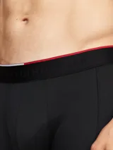 Pack de tres bóxer tipo boxer brief negros, con cintura elástica con logo Tommy Hilfiger en blanco y una franja roja.