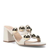 Sandalia de cuero sintético color blanco con taco cuadrado y apliques metálicos dorados.