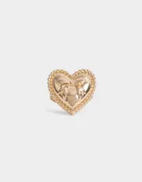 Anillo dorado con forma de corazón y moño en relieve.