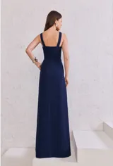 Mono largo azul marino, sin mangas, con escote halter y abertura en el pecho. El pantalón es de corte ancho y fluido.