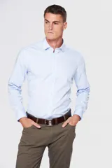 Camisa de vestir azul, entallada, con cuello clásico y manga larga, sin bolsillo.