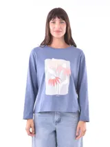 Remera celeste de manga larga con cuello redondo y estampado de flores en el frente.