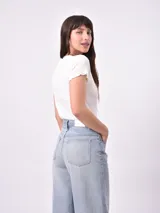 Remera blanca de punto con cuello en V y mangas cortas con volados.