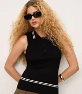 Top de punto sin mangas color negro, ajustado al cuerpo, con cuello polo que presenta ribetes blancos contrastantes. Tiene un cierre frontal de tres botones y un ribete blanco en el ruedo inferior.