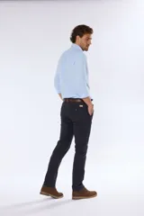 Pantalón de vestir azul marino, de corte recto, con bolsillos laterales y traseros. Se ajusta a la cintura con cinturón de cuero marrón.