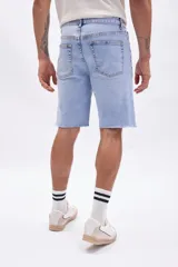 Bermuda de jean de hombre, color azul claro lavado, con roturas y terminación deshilachada en el ruedo.