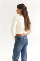 Cinto de cuero color marrón con hebilla metálica y tachas plateadas.