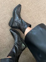 Bota marrón con estampado de piel de cocodrilo, caña media, punta cuadrada y tacón geométrico negro.