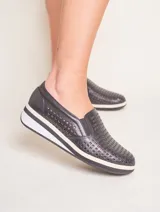 Panchita clásica de cuero calado color negro, con elástico en los laterales y suela de goma blanca con detalle de línea negra.