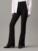 Leggings negros de punto milano con talle alto, corte slim, pierna acampanada y bajo abierto. Confeccionados con un 66% de viscosa, 30% de nailon y 4% de elastano.