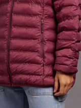 Campera acolchada color burdeos, con capucha y cierre frontal.