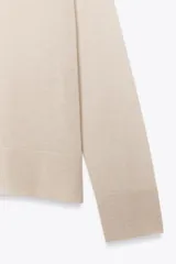 Jersey de punto color borgoña, con cuello redondo, manga larga y bajo con aberturas laterales.