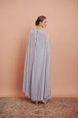 Vestido largo de encaje color plata con brillos y cuello halter. Incluye capa de gasa larga.