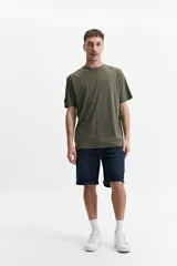 Remera verde militar de manga corta con estampado de soles y texto en la espalda.