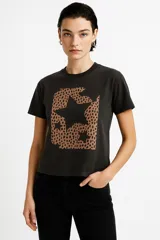 Remera de algodón color crudo con estampado de un labial rojo y texto en color bordó que dice "It's OK to wear lipstick". Corte clásico, cuello redondo y mangas cortas.