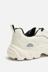 Zapatillas grises con cordones, capellada combinada y suela chunky con diseño irregular.