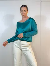 Blusa de color verde petróleo, con corte amplio y mangas largas, confeccionada en tela suave y fluida.