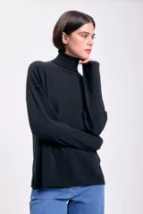 Polera negra de punto de rib con cuello alto y mangas largas.